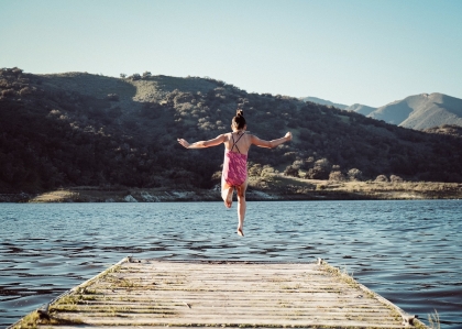 Girl jumping off a dock for fun